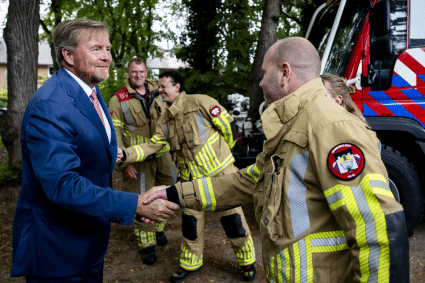 Koning Willem-Alexander spreekt met brandweerlieden tijdens een bezoek aan Austerlitz ANP